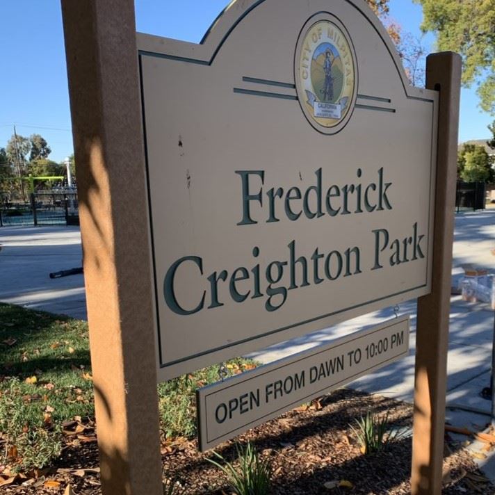 A wooden sign that reads Frederick Creighton Park