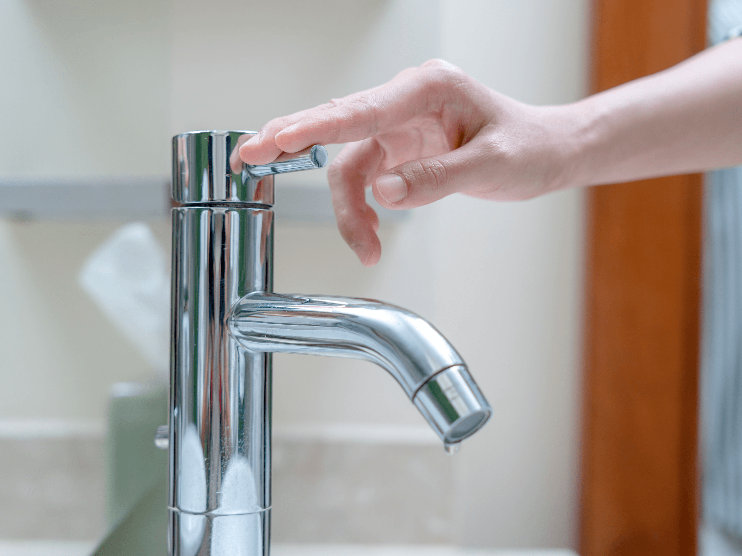 Person turning off faucet