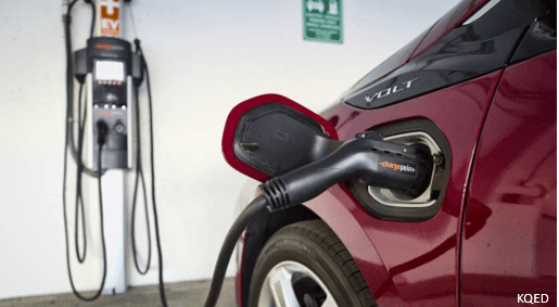 Red electric vehicle plugged into a charger